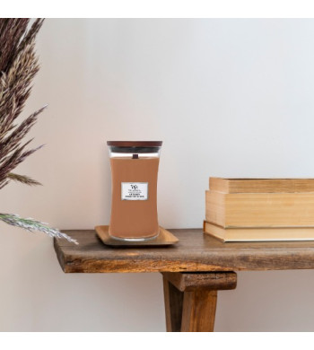 Large bougie Myrrhe et bois de santal crépitante woodwick chez artizen mise en contexte table avec livres
